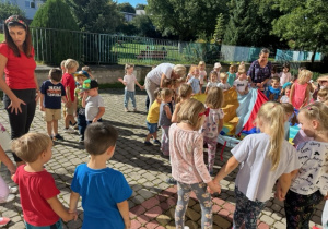 Dzieci bawią się na placu przedszkolnym przy muzyce