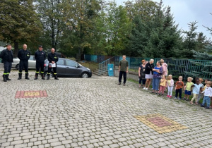 Strażacy dziękują dzieciom za szybkie wyjście z przedszkola.