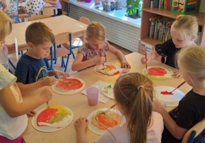 Dzieci malują farbami talerzyk papierowy