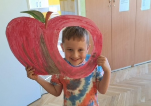 Chłopiec pozuje do fotobudki- jabłko