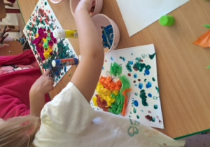 Dzieci malują farbami tło rysunku