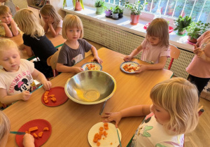 Dziewczynki kroją marchewkę nożem plastikowym