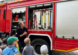 Pan strażak pokazuje dzieciom sprzęt strażacki