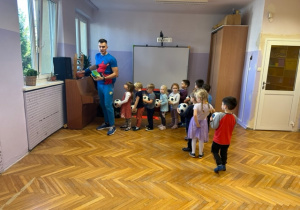Dzieci ustawione w rzędzie trzymają piłkę