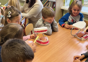 Dzieci uczą się szczotkować zęby na makiecie