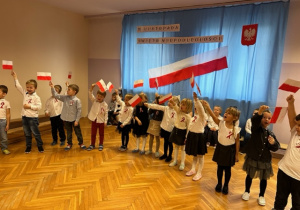 Dzieci z grupy III śpiewają piosenkę i machają flagami