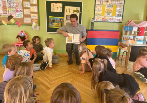 Pan Konrad pokazuje dzieciom ilustracje w książce