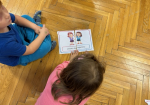 Dzieci siedzą na podłodze składają obrazek pocięty na kilka części