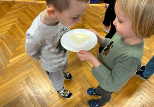 Dzieci zlizują językiem miód z talerzyka