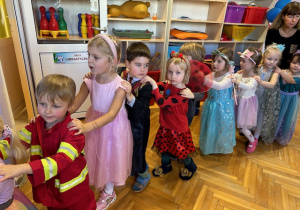 Dzieci ubrane w stroje karnawałowe tańczą