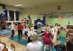Dzieci tańczą w małych kółeczkach do muzyki