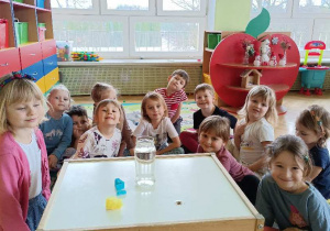Dzieci obserwują doświadczenie dotyczące mieszania barw za pomocą bibuły