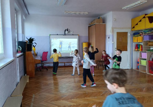 Dzieci wykonują zabawy ruchowo-naśladowcze przy muzyce