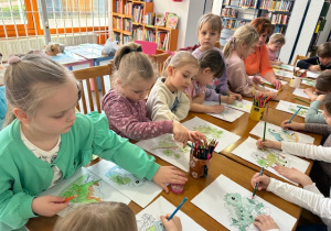 Dzieci z wielkim zaangażowaniem kończą kolorować swój obrazek