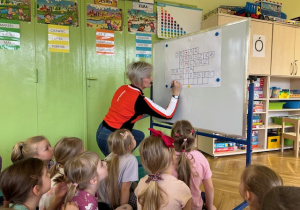 Dzieci rozwiązują Krzyżówkę a nauczyciel wpisuje hasło na tablicy