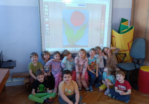 Dzieci pozują do zdjęcia grupowego przy wspólnie wykonanej pracy