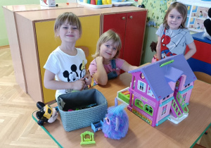 Dziewczynki bawią się domkiem dla lalek