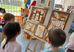 Dzieci oglądają wystawę obrazów "Kawą malowane" pt. "Łódź"