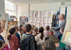 Dzieci stoją i oglądają wystawę swoich prac- pisanek