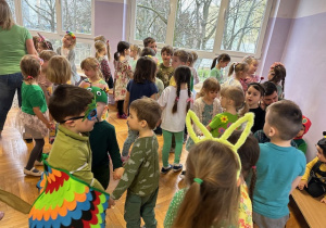 Dzieci tańczą do wiosennej piosenki w parach trzymając się za ręce