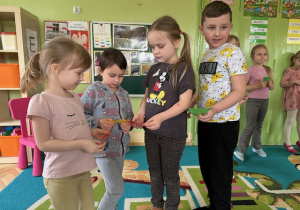Dzieci stoją w kółeczku z figurą - trójkąt i sylabą taką samą - czytają sylaby