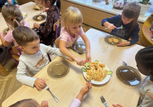 Dziewczynka nakłada sałatkę na talerzyk