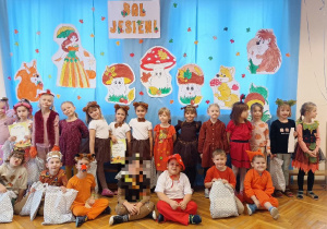 Dzieci z grupy Pszczółek pozują do zdjęcia grupowego na tle dekoracji jesiennej