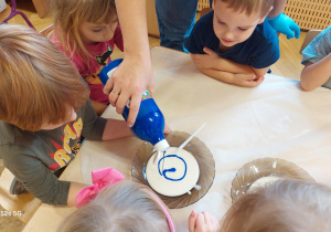 Pani wlewa do miski z wodą i mąką farbę