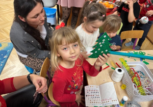 Dziewczynka pokazuje swoją ozdobioną choinkę