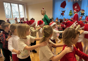 Dzieci ustawione w pociąg idą po sali przy muzyce