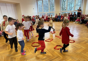 Dzieci chodzą po sali i na dany sygnał mają wskoczyć do szarfy