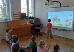 Chłopiec wykonuje ćwiczenie na tablicy multimedialnej
