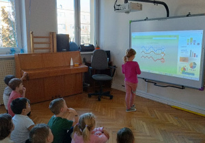 Dziewczynka wykonuje ćwiczenie na tablicy multimedialnej
