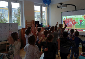 Dzieci wykonują ruchy widoczne na ekranie