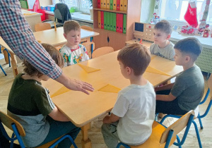 Chłopcy słuchają instrukcji wykonania świec
