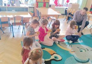 Dzieci oglądają i wąchają świece wykonane z wosku pszczelego