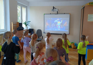 Dzieci bawią się przy muzyce naśladując układy taneczne