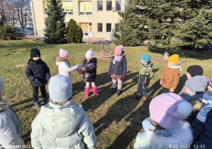 Dzieci stoją w kole i rzucają do siebie nawzajem