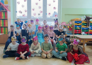 Dzieci pozują do wspólnego zdjęcia w ozdobionych przez siebie maskach karnawałowych