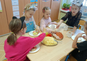 Dzieci samodzielnie nakładają składniki na kanapkę