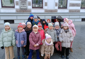 Dzieci pozują do wspólnego zdjęcia przy pomniku J. Tuwima