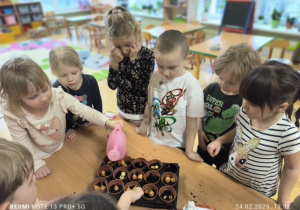 Dzieci podlewają cebulki wodą