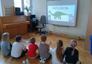 Dzieci biorą udział w zagadkach i quizach na temat dinozaurów oraz poznają ciekawostki na ich temat