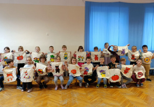 Dzieci pozują do zdjęcia grupowego z wykonanymi przez siebie workami