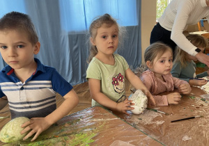 Dziewczynka przykleja kolorowy papier na jajko styropianowe