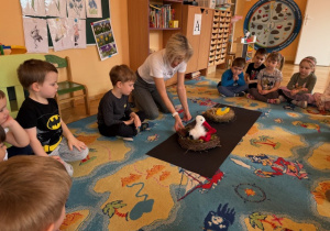 Dzieci słuchają i oglądają gniazdo bociana