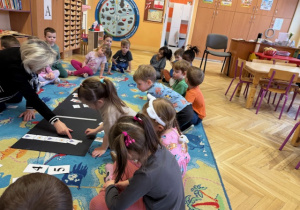 Dziewczynka układa rytmicznie kwiaty po linii