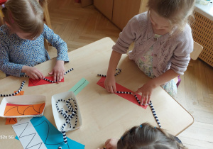 Dzieci precyzyjnie układają na liniach sznurek