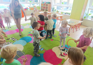 Dzieci trzymają koła w ręku i naśladują jeżdżące auta