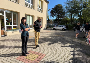 Pan Strażak objaśnia dzieciom cel spotkania na placu przedszkolnym